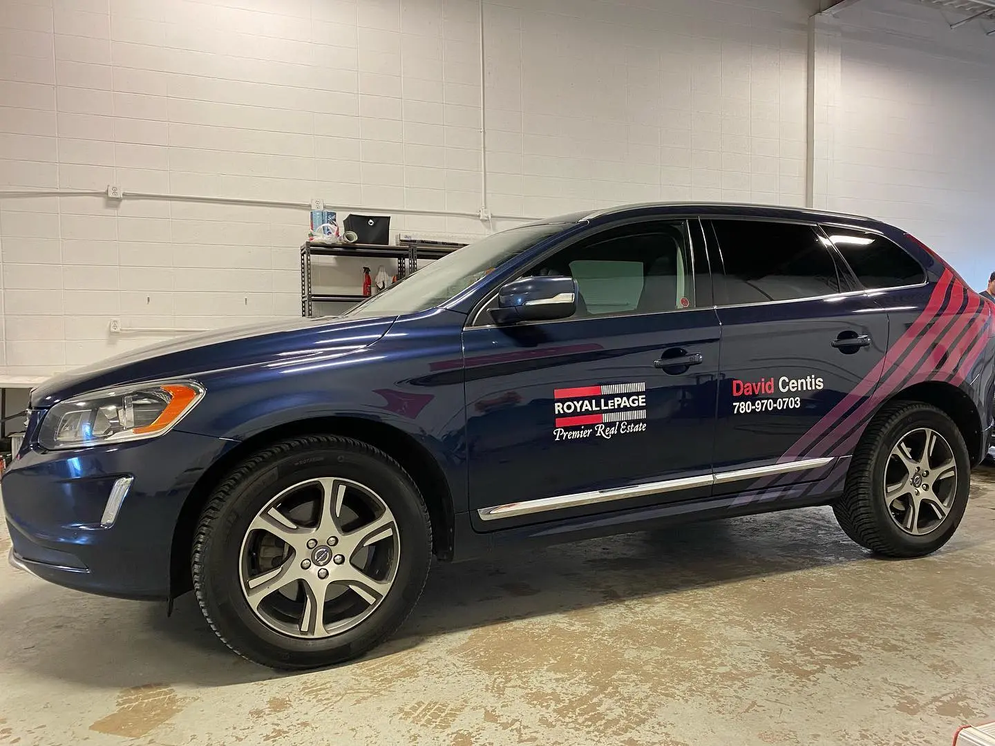 Door vinyl on a dark blue Volvo SUV for a Royal LePage agent, carrying the brokerage logo, the agent name, and a phone number