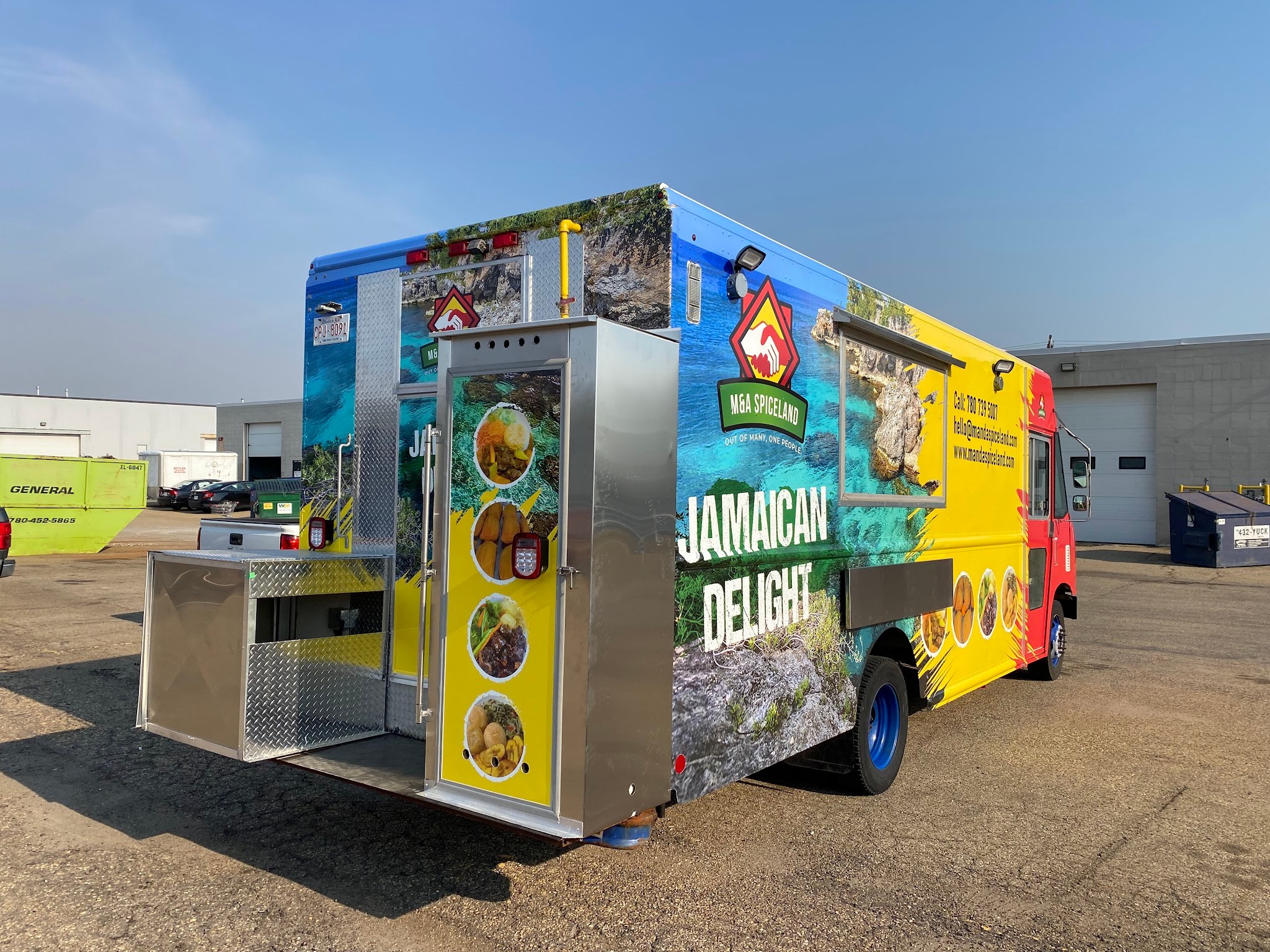 A Jamaican Delight food truck wrapped in a full colour printed graphic, parked outdoors with the service window open
