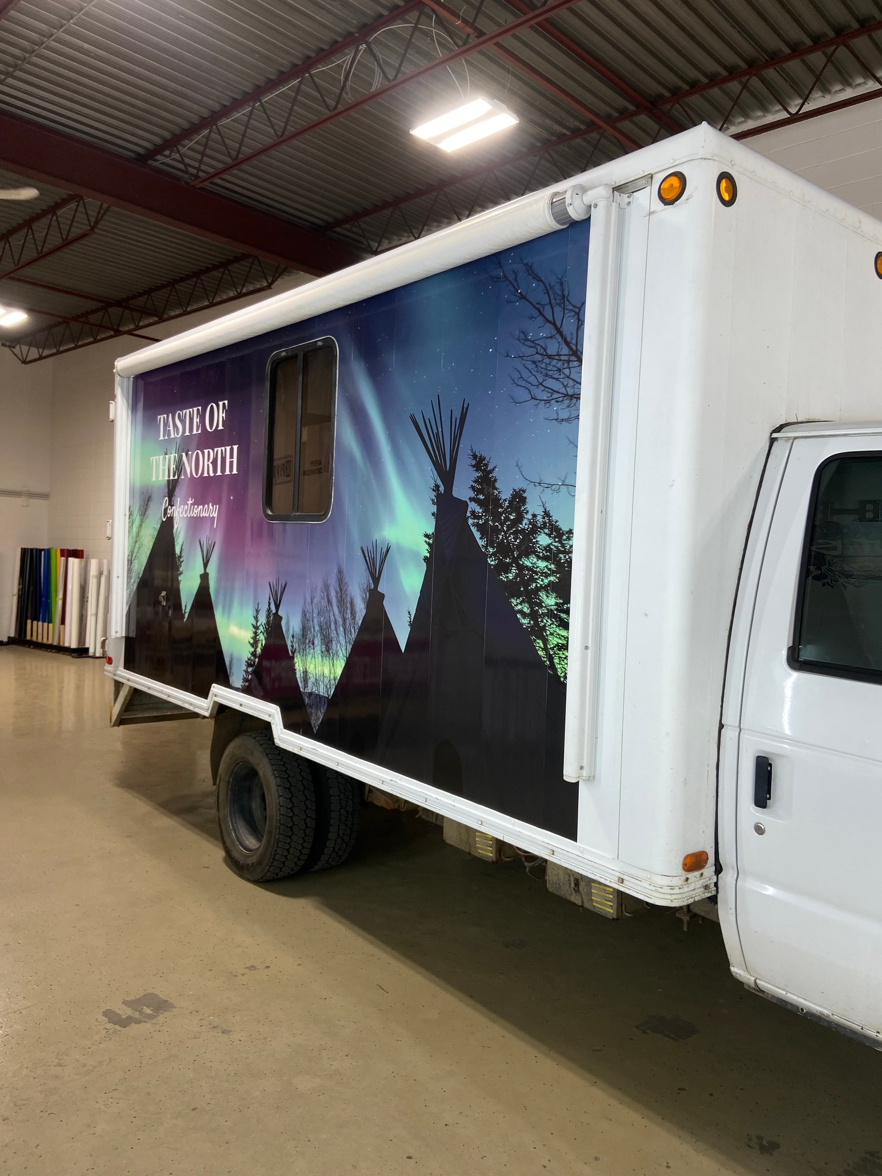 A Taste of the North confectionary trailer wrapped in a large format printed northern lights and tipi scene running the full length of the body